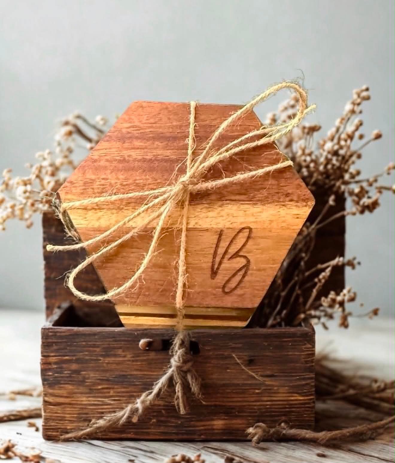 Hexagon wood coaster engraved with a monogram B, tied with twine in a wooden gift crate