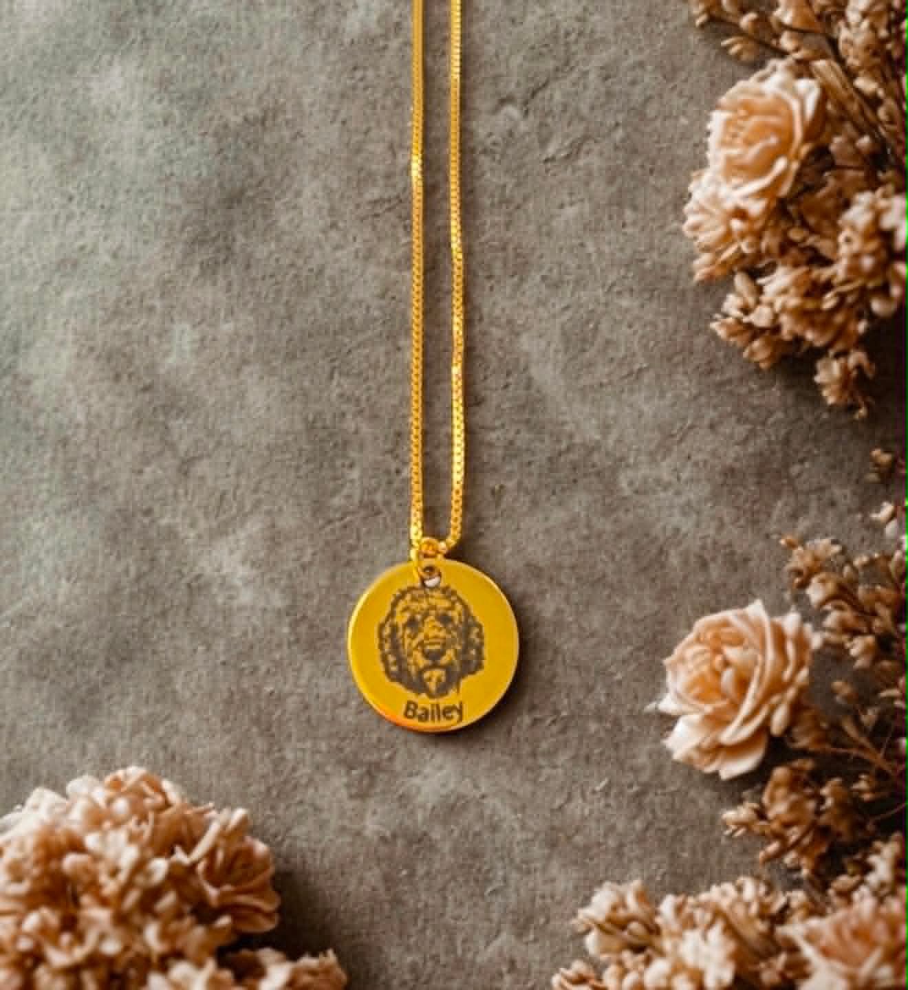 Gold pendant necklace engraved with a dog's portrait and the name Bailey