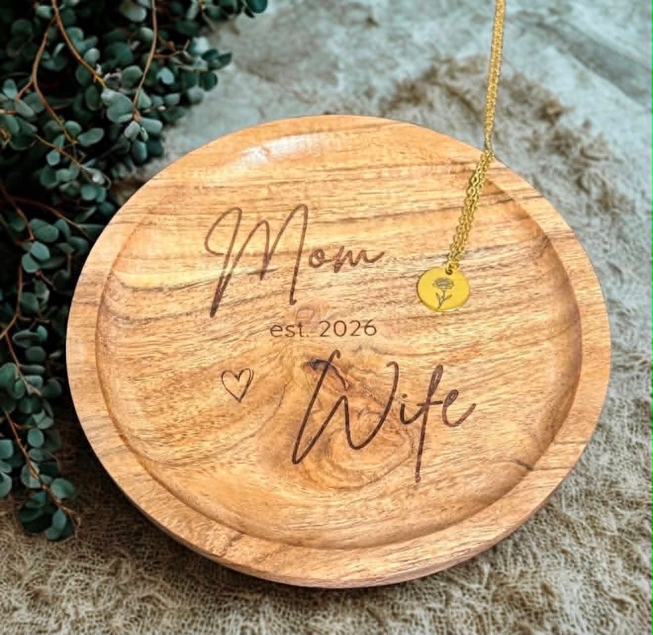 Round wood trinket dish engraved with Mom and Wife, Est. 2026, paired with a gold birth flower necklace